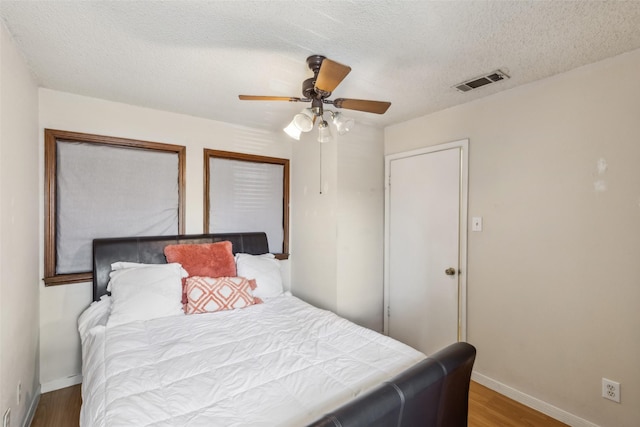 bedroom featuring a textured ceiling, hardwood / wood-style flooring, and ceiling fan