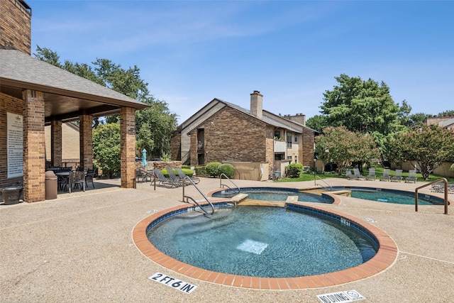 view of pool featuring a community hot tub and a patio