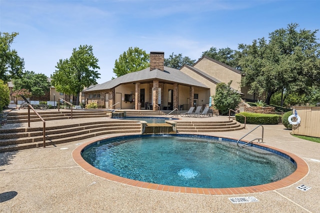 view of pool with a patio area and pool water feature