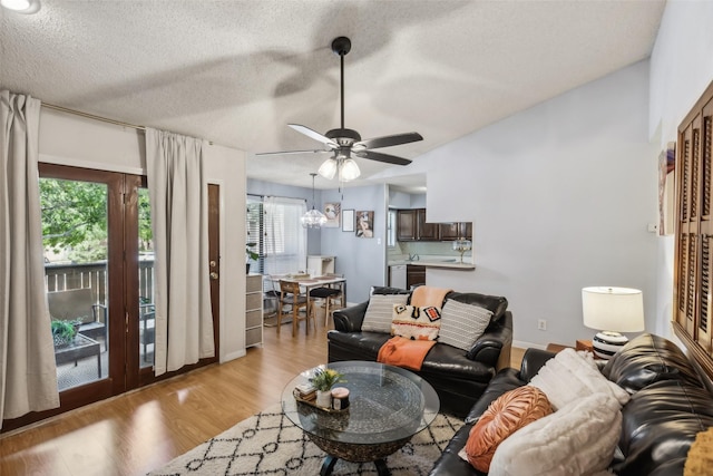 living room with a textured ceiling, light hardwood / wood-style floors, a wealth of natural light, and ceiling fan