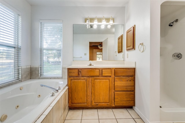 bathroom with a relaxing tiled tub, vanity, and tile patterned flooring