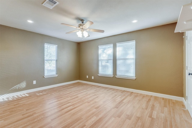 spare room with ceiling fan, a wealth of natural light, and light hardwood / wood-style flooring