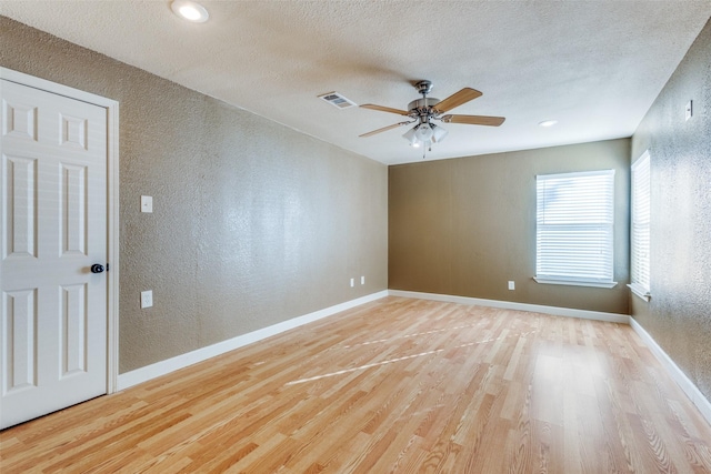 empty room with ceiling fan, a textured ceiling, and light hardwood / wood-style flooring