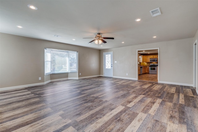 unfurnished living room with ceiling fan and dark wood-type flooring