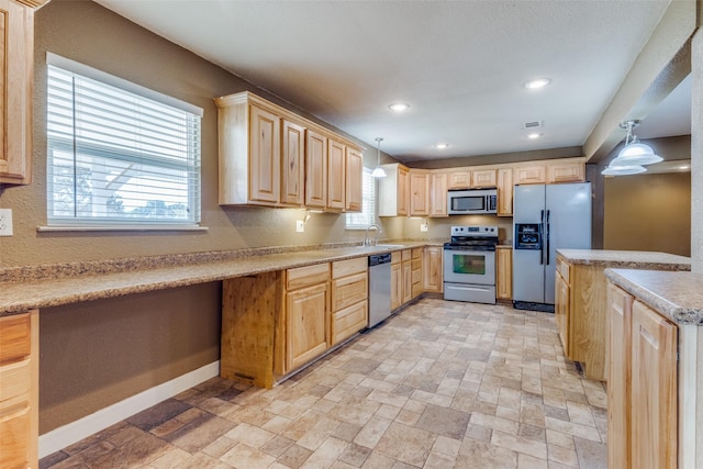 kitchen featuring pendant lighting, built in desk, sink, appliances with stainless steel finishes, and light brown cabinets