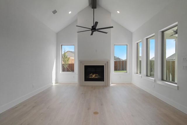 unfurnished living room with beam ceiling, high vaulted ceiling, and light hardwood / wood-style flooring