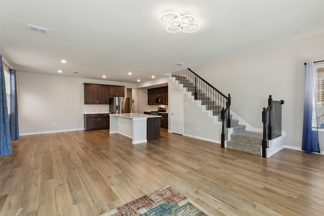 unfurnished living room with light wood-type flooring and sink