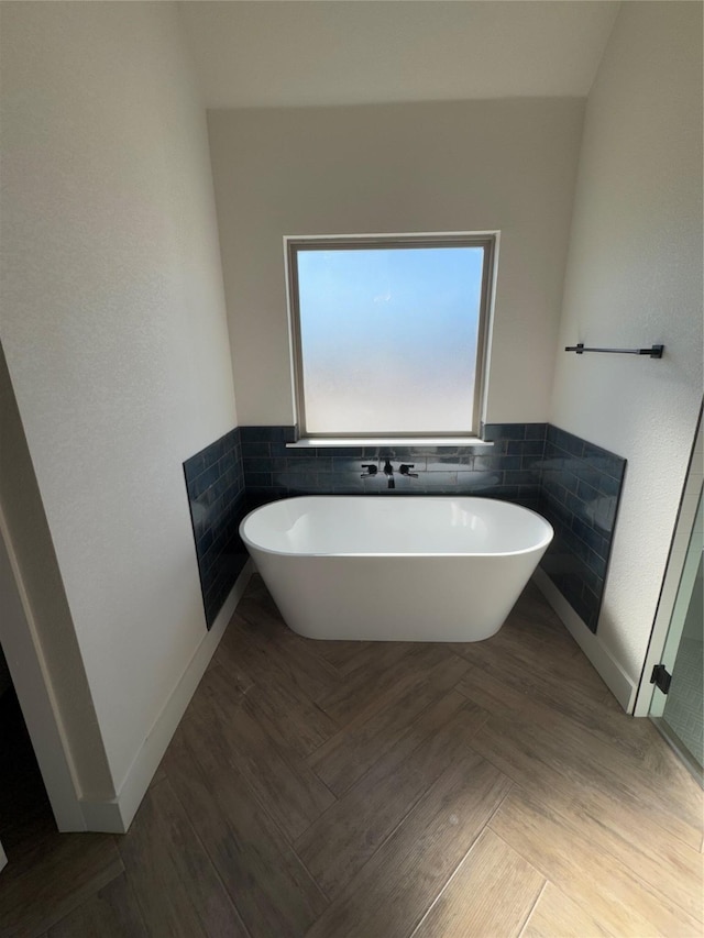 bathroom featuring a tub to relax in and tile walls