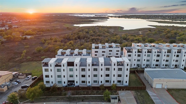 aerial view at dusk featuring a water view