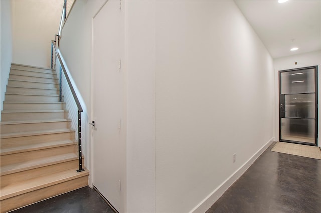 stairs featuring concrete flooring