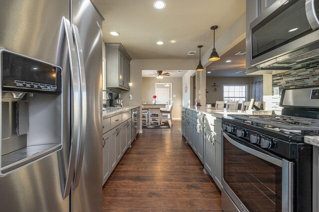 kitchen with decorative light fixtures, sink, decorative backsplash, and stainless steel appliances