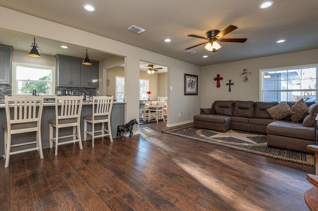 living room with a fireplace, dark hardwood / wood-style floors, and ceiling fan