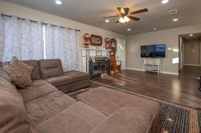 living room with plenty of natural light, dark wood-type flooring, and ceiling fan