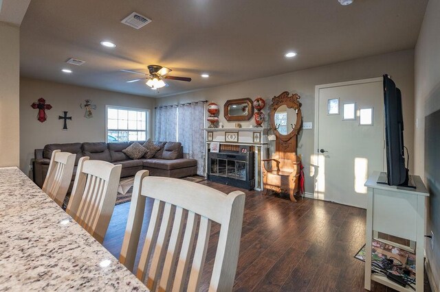 living room with ceiling fan and dark wood-type flooring