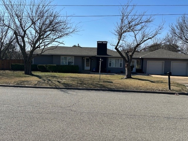 ranch-style house featuring a garage and a front yard