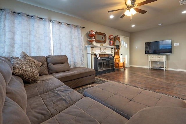 living room with a brick fireplace, ceiling fan, and hardwood / wood-style flooring