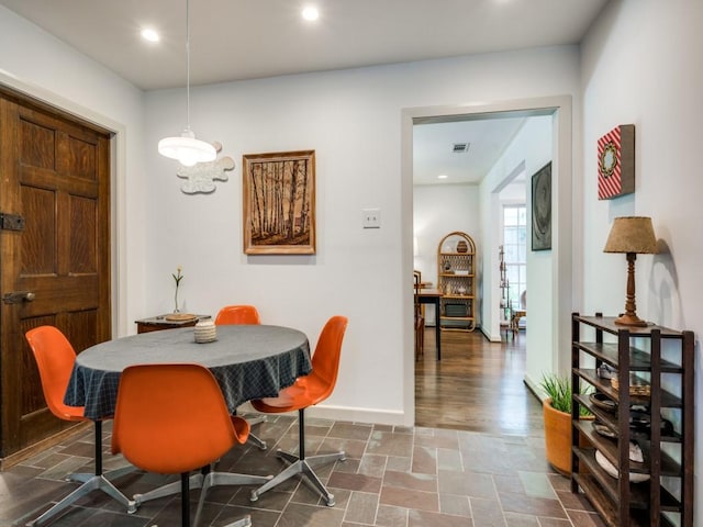 dining room with stone finish flooring, recessed lighting, visible vents, and baseboards