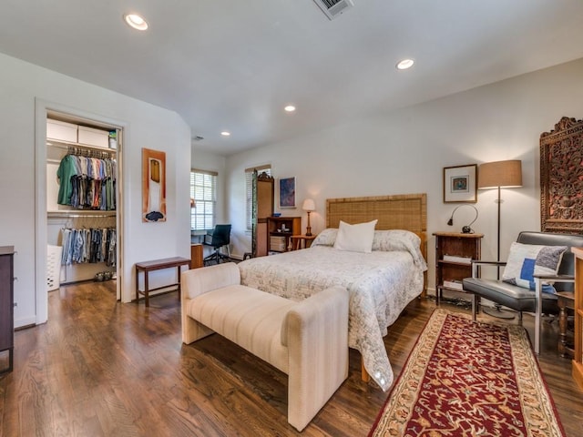 bedroom with recessed lighting, dark wood-style flooring, visible vents, a closet, and a walk in closet