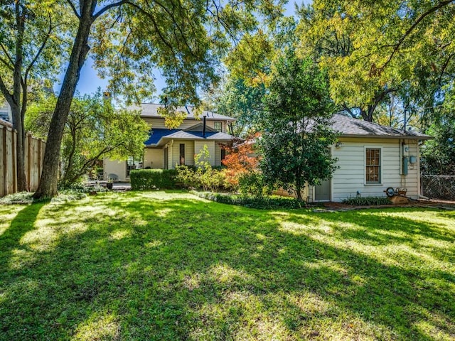 view of front of property featuring fence and a front lawn