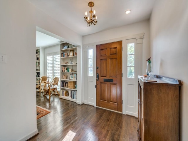 entrance foyer featuring an inviting chandelier, plenty of natural light, and dark wood-type flooring