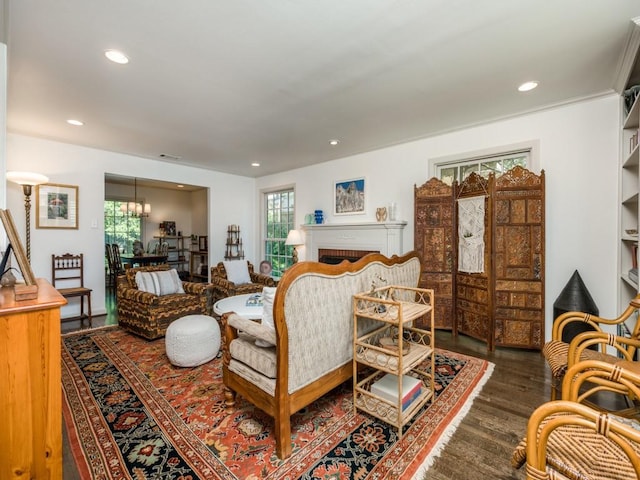 living room featuring dark wood-style floors, a brick fireplace, visible vents, and recessed lighting