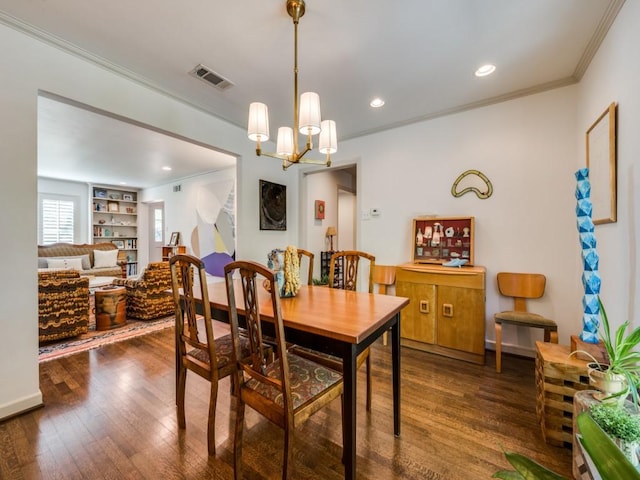 dining room featuring built in features, dark hardwood / wood-style flooring, an inviting chandelier, and crown molding