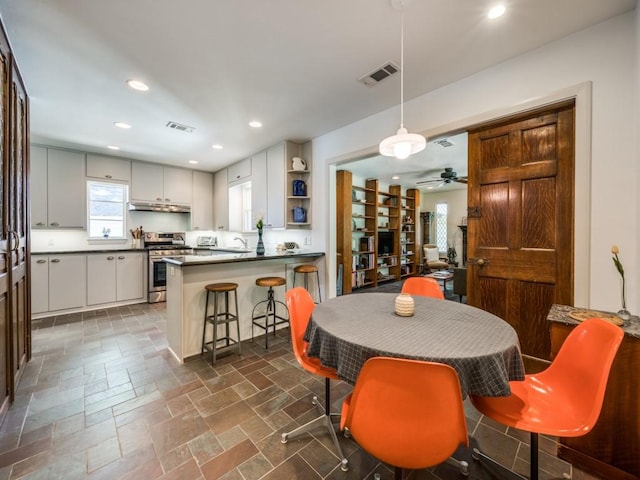 dining space featuring a ceiling fan, visible vents, stone tile flooring, and recessed lighting