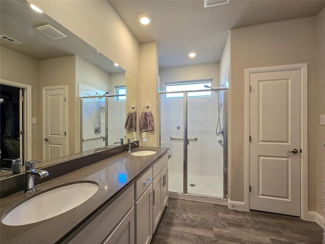 bathroom with hardwood / wood-style floors, vanity, and walk in shower