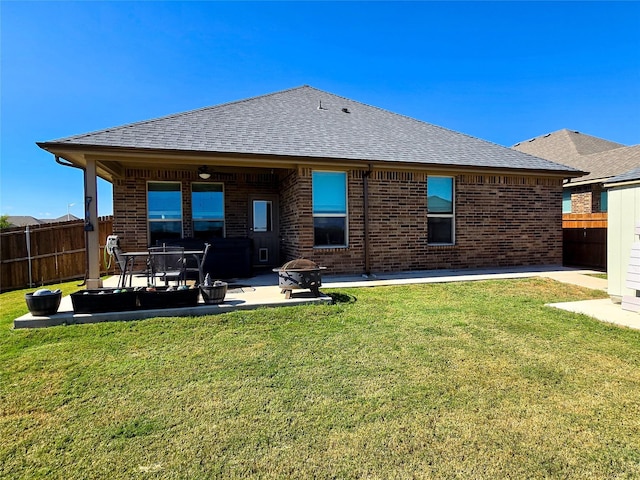 rear view of property with a fire pit, a patio area, and a lawn