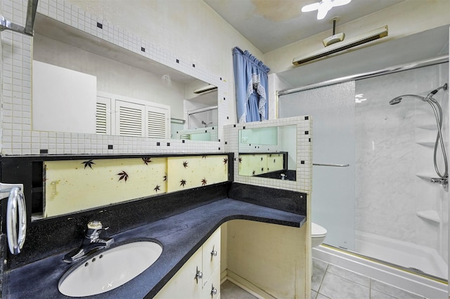 bathroom with backsplash, vanity, tile patterned flooring, toilet, and a shower with shower door