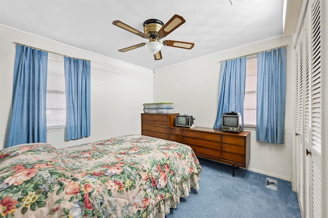 carpeted bedroom featuring ceiling fan, crown molding, and a closet