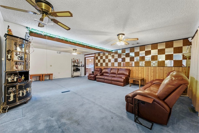 carpeted living room with wooden walls and a textured ceiling