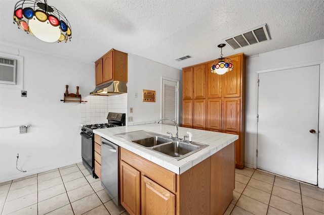 kitchen featuring dishwasher, sink, decorative backsplash, tile counters, and range