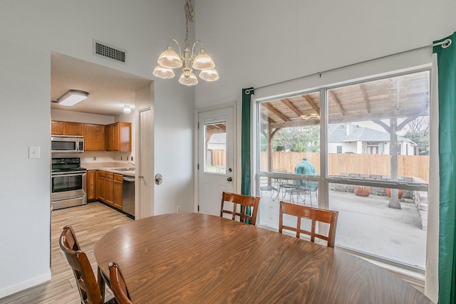 dining area with a chandelier, light hardwood / wood-style flooring, and sink