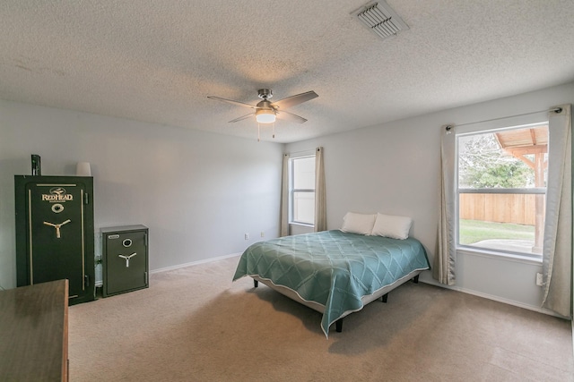 bedroom featuring multiple windows, a textured ceiling, carpet flooring, and ceiling fan