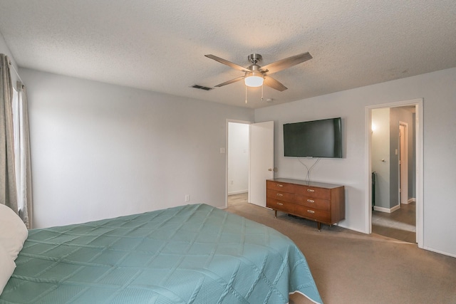 carpeted bedroom featuring ceiling fan and a textured ceiling