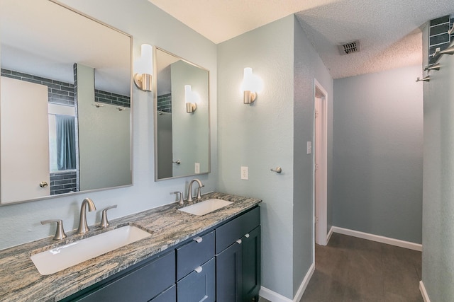 bathroom with vanity, wood-type flooring, and a textured ceiling