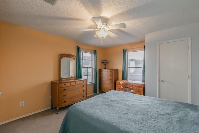 bedroom with carpet flooring, ceiling fan, and a textured ceiling