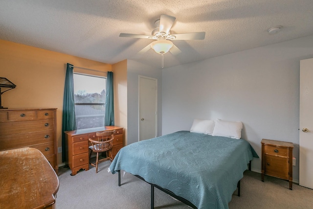 bedroom with ceiling fan, light colored carpet, and a textured ceiling