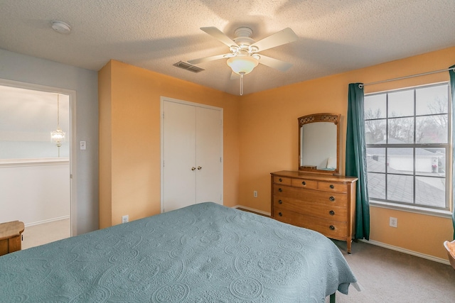 bedroom with carpet flooring, ceiling fan, and a textured ceiling