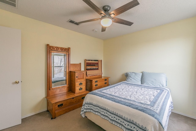 carpeted bedroom with a textured ceiling and ceiling fan