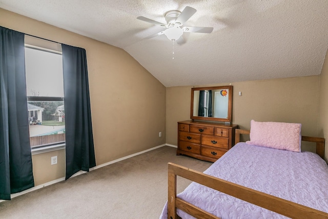 bedroom with a textured ceiling, carpet floors, vaulted ceiling, and ceiling fan