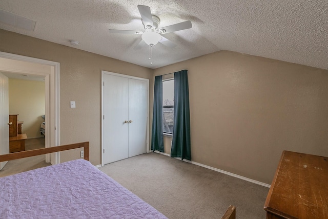 bedroom with carpet flooring, ceiling fan, vaulted ceiling, a textured ceiling, and a closet