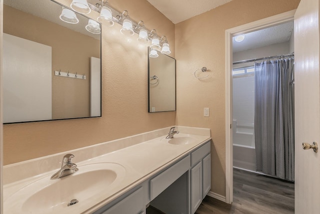 bathroom with hardwood / wood-style floors, vanity, and a textured ceiling