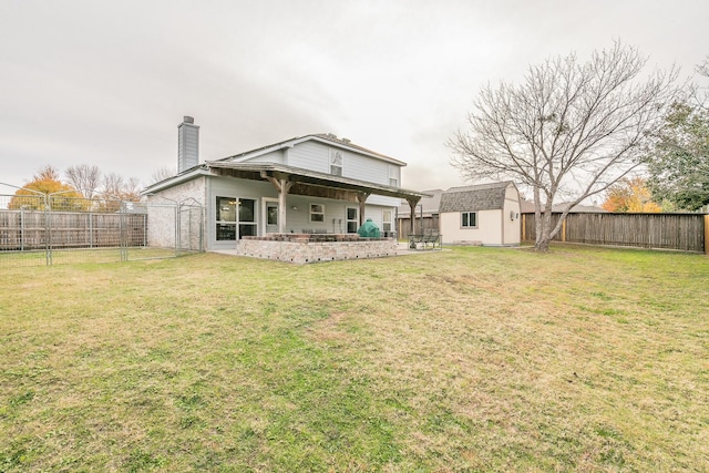 rear view of property with a lawn, a storage shed, and a patio