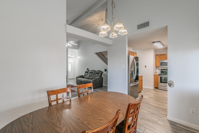 dining area featuring washer / clothes dryer, ceiling fan with notable chandelier, and light wood-type flooring