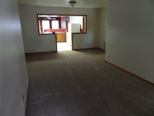 spare room featuring ceiling fan and carpet floors