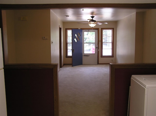 entryway featuring ceiling fan, light carpet, and washer / clothes dryer