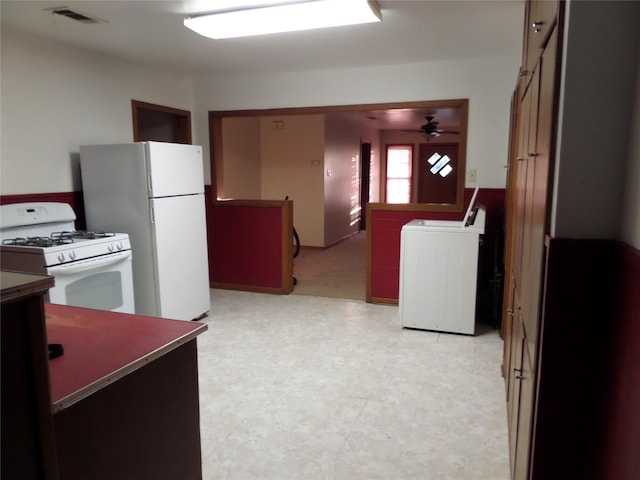 kitchen with ceiling fan, washer / dryer, and white appliances