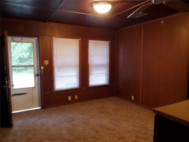 carpeted empty room with wooden walls